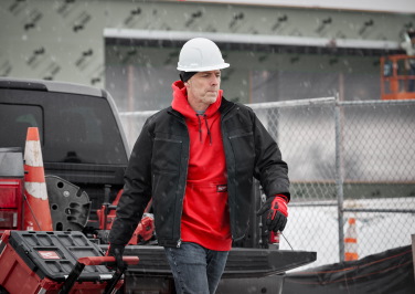 A contractor walks through a construction site in Milwaukee workwear.