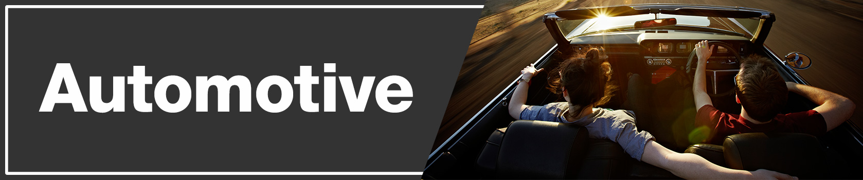 Man and woman riding in a convertible passenger car