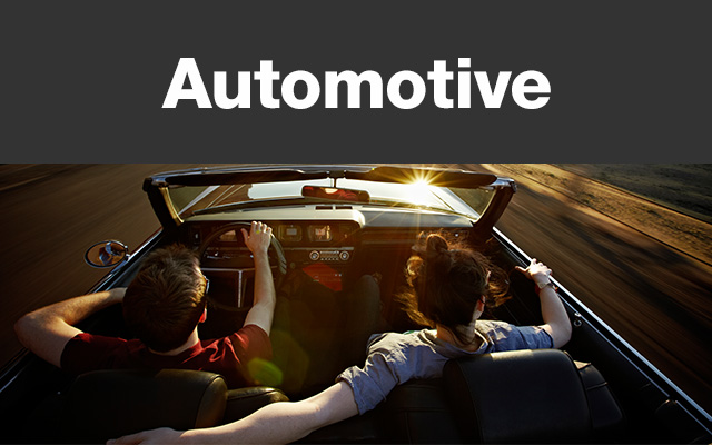 Man and woman riding in a convertible passenger car