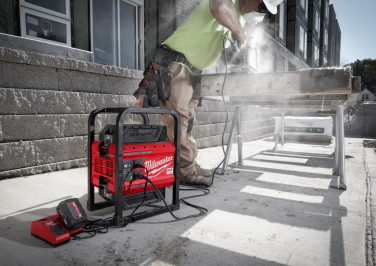 Milwaukee MX FUEL power supply sits in foreground powering the saw of a workman cutting wood behind