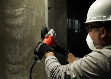 Workman using a Milwaukee corded cutoff tool on the jobsite.