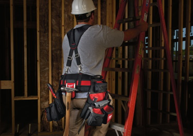 A workman climbs a stepladder on the jobsite wearing a Milwaukee tool belt full of Milwaukee tools